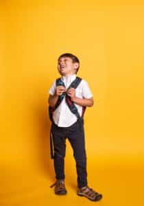 Back to school checklist for KS2 parents - child ready with a backpack for September term