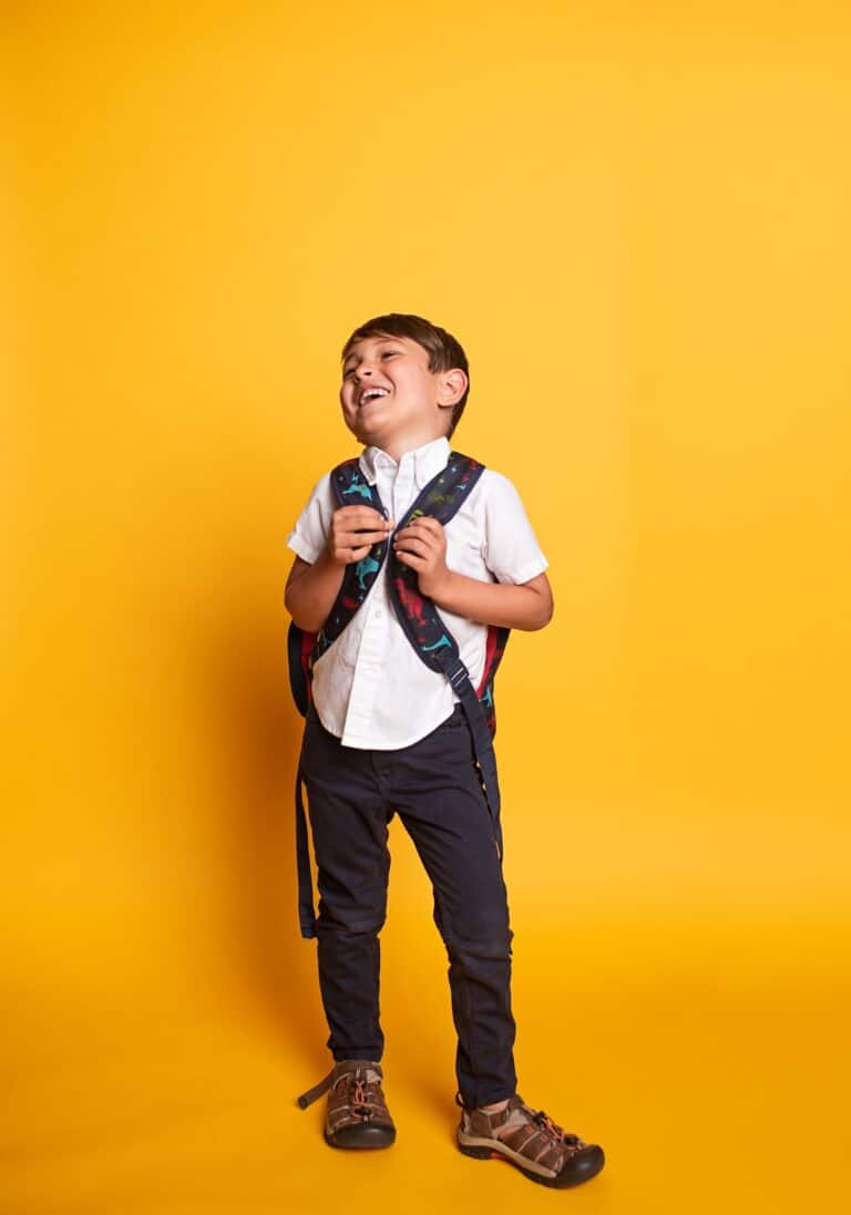 Back to school checklist for KS2 parents - child ready with a backpack for September term