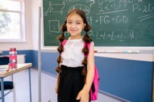 Smiling KS2 child wearing a backpack, one of many families experiencing back to school nerves before the new term