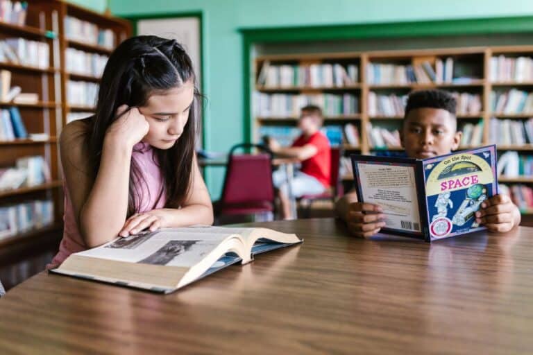 Two KS2-age children reading in a school library, illustrating this KS2 curriculum guide